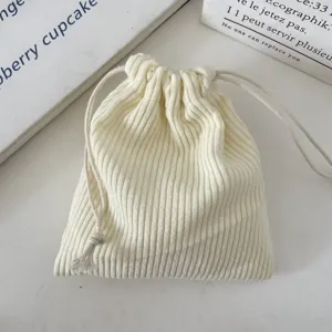 Close-up of cream corduroy drawstring pouch showing detailed ribbed fabric texture
