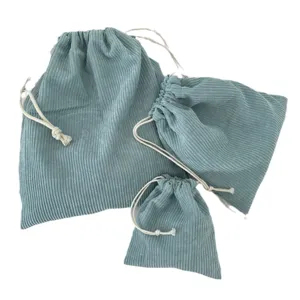 Set of 3 light blue corduroy drawstring cosmetic storage bags on white background.