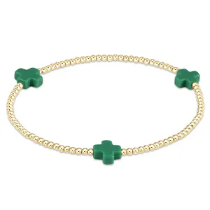 Gold bead bracelet featuring green cross charms and elastic design for women stylish