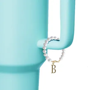 Gedetailleerd overzicht van een elegante parelarmbandhanger met gouden letter B hanger.
