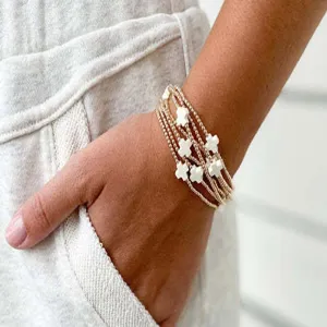Elegant multi-strand gold beaded bracelet featuring stylish white clover charms for women.