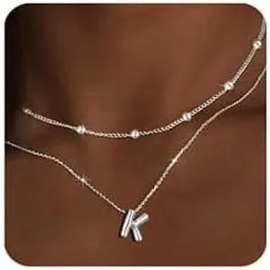 Vista dettagliata di una elegante collana d'argento a doppio strato con ciondolo lettera K.