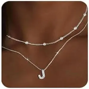 Elegante collana con iniziale a strati con un delicato ciondolo a lettera e sottile catena di perle.