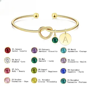Bracciale rigido con iniziale personalizzata e pietra portafortuna mensile con nodo d'amore.