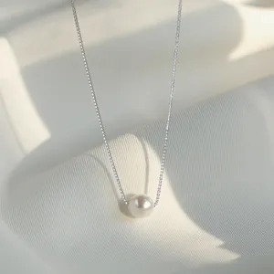 Elegant silver chain necklace with a single white pearl pendant, delicate fashion detail.