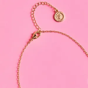 Gold-tone metal chain necklace detail with letter charm and lobster clasp for women.