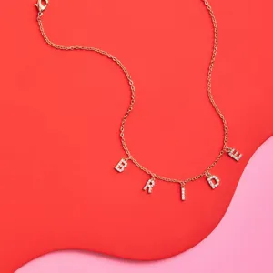 Closeup detail of elegant gold-plated rhinestone BRIDE letter pendant necklace for bridal gift.