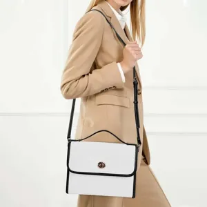 Elegante bolso de hombro de cuero blanco con ribete negro y detalle de cierre giratorio.