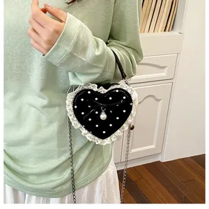 Vue détaillée du mini sac à main en forme de cœur avec pois, dentelle et perle.