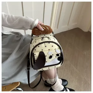Vista dettagliata di un mini zaino cane cartone animato con stelle e manico in peluche.