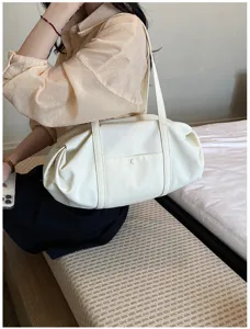 Detail shot of a casual white shoulder bag with soft gathered design and double straps.
