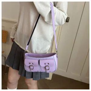 Primo piano dettaglio della borsa a baguette spalla viola chiaro con tasca doppia e fibbie.