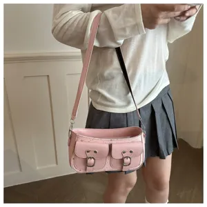 Vista dettagliata di una borsa a tracolla rosa retrò con tasche anteriori e fibbie in metallo.