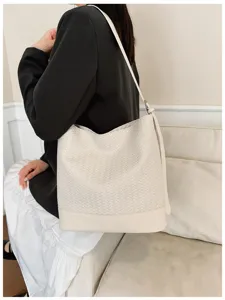 Detail shot of a stylish woven bucket bag in beige, perfect for everyday retro style.
