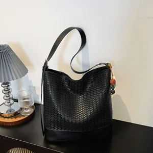 Black woven leather bucket bag with shoulder strap and chic bead charm for women.