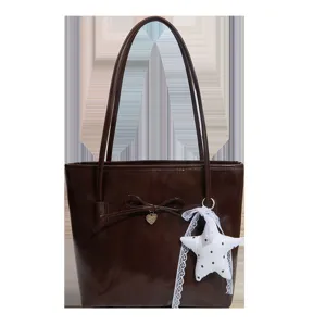 Brown tote bag for women with bowknot and star pendant, stylish PU leather shoulder handbag.