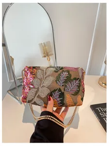 Prachtige handtas met pailletten borduurwerk en gouden ketting, prachtig detailbeeld.