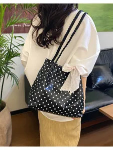 Vista detallada del gran bolso tote negro de lunares con lazo para mujeres de moda.