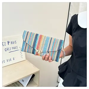 Colorful woven clutch bag detail, ethnic style envelope purse with metallic clasp decoration.