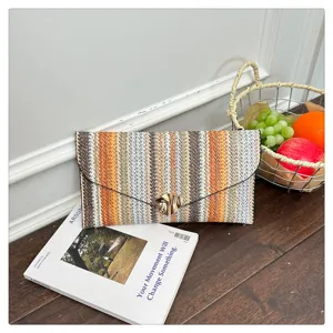 Colorful straw woven envelope clutch bag with metal clasp for women fashion daily use.