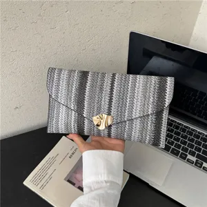 Woven envelope clutch bag for women, stylish black and white striped handbag with gold buckle.