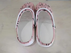 Rosa lässige Clogs Schuhe mit klassischen Belüftungsöffnungen und weißem Fersenriemen.