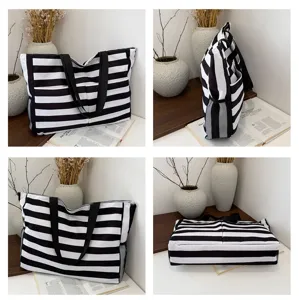 Detail view of black and white striped canvas tote bag, featuring sturdy handles and side mesh pockets.