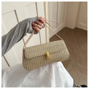 Chic sac porté épaule baguette en paille pour femme avec bordure en cuir rose et fermoir.