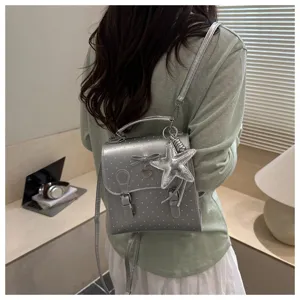 Detailed view of sweet silver polka dot backpack with cute star and bow charms, stylish design.