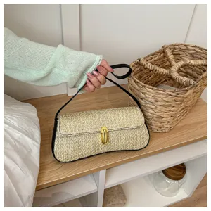 Vue détail du sac baguette épaule femme en paille tissée avec fermoir chic et bord.
