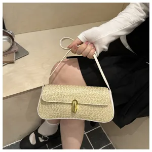 Vue rapprochée du sac à bandoulière baguette en paille tissée élégant avec serrure dorée.
