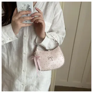 Pink polka dot dumpling bag detail, featuring a cute bow charm and stylish handbag design.