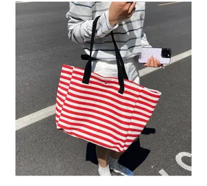 Red and white striped canvas tote bag detail, casual commuter shoulder bag style for daily use.