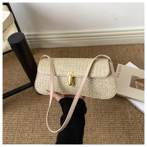 Sac baguette d'épaule en paille tissée avec une bordure en cuir rose et serrure dorée.