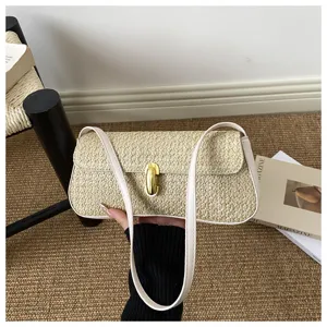 Sac baguette d'épaule en paille tissée, détail élégant sac bandoulière avec serrure.