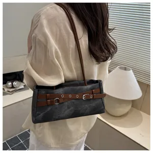 Close-up detail of the stylish contrast belt denim shoulder bag showing unique buckle design.
