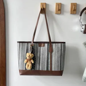 Stylish striped canvas tote bag with brown leather trim and cute bear pendant for women.