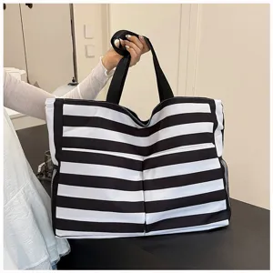 Black and white striped canvas tote bag showing large capacity design and side pocket details.