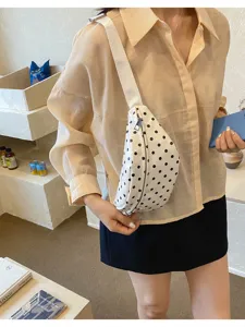 Detail shot of white polka dot waist bag worn by model, casual style chest bag view.