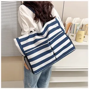 Detail view of the casual blue and white striped canvas tote bag with large capacity for women.