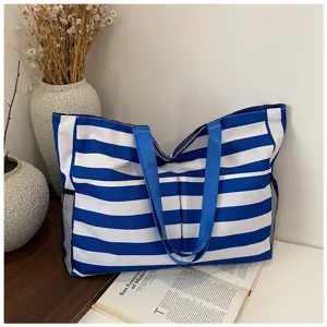 Blue and white striped canvas tote bag detail, casual aesthetic style with double straps.