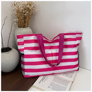 Close-up detail of the pink white striped canvas tote bag with side mesh pockets and straps.