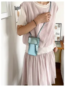 Glossy metallic finish phone bag detail shot, stylish vertical crossbody mini bag for women styling.
