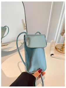 Close-up view of the glossy light blue mini phone crossbody bag with chic metallic finish.