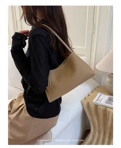 Elegant minimalist shoulder bag for women, chic beige armpit bag for daily commute.