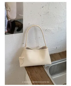 Minimalist beige shoulder bag detail, elegant retro underarm bag design with fine strap.