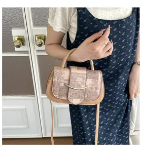 Primer plano detallado de un elegante bolso de hombro patchwork con cierre metálico.