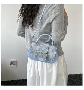 Detalle del bolso cruzado retro que muestra la tela única y la hebilla de metal elegante.