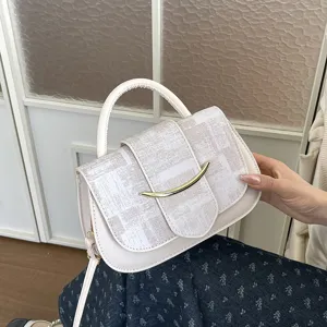 Elegante bolso de mano y bandolera para mujer con solapa estampada y barra de metal.