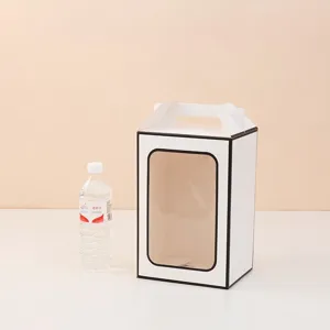 Detailed view of white paper gift box with clear window and handle next to water bottle